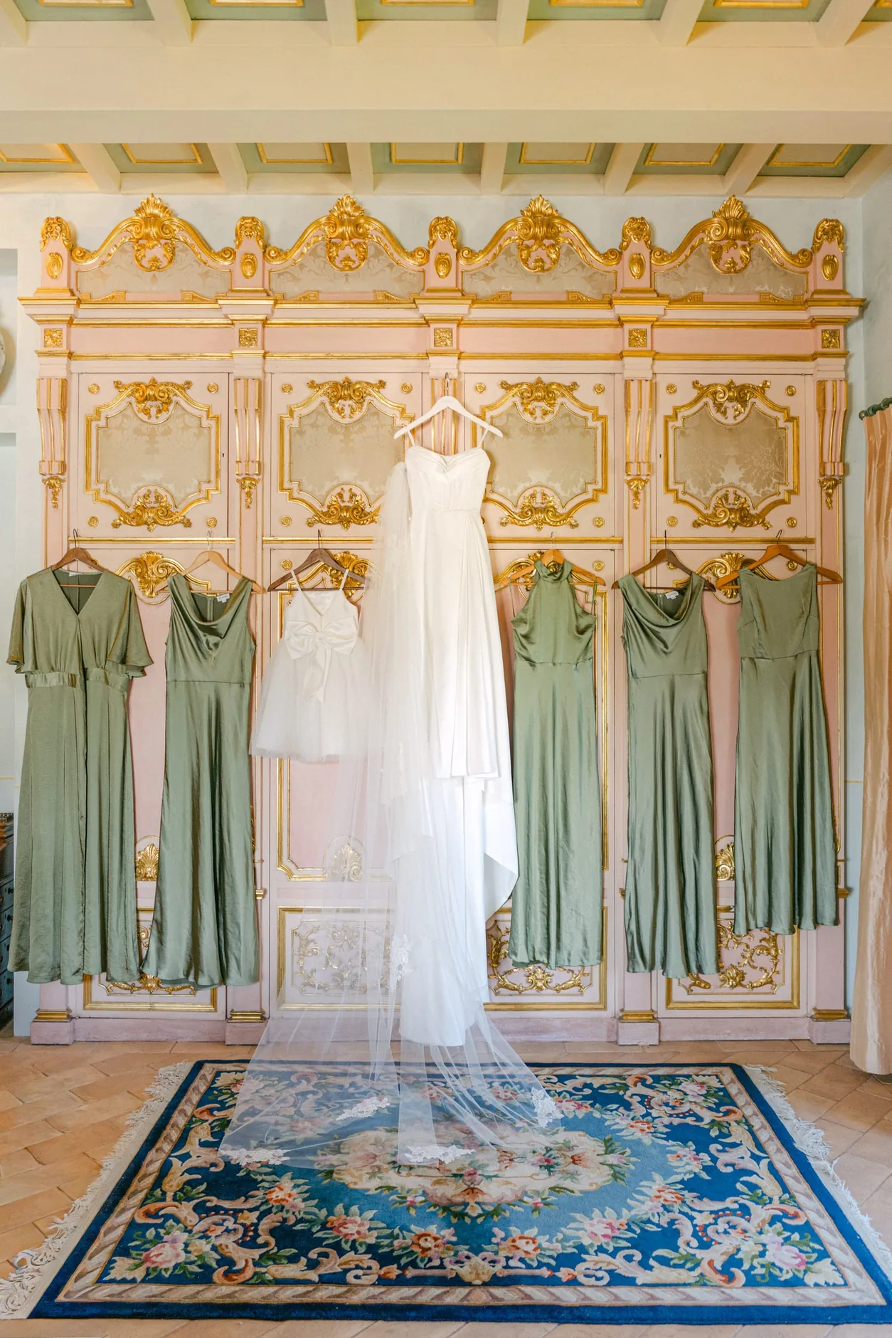 L'abito da sposa appeso in una sala decorata della Tenuta del Gallo, tra gli abiti delle damigelle
