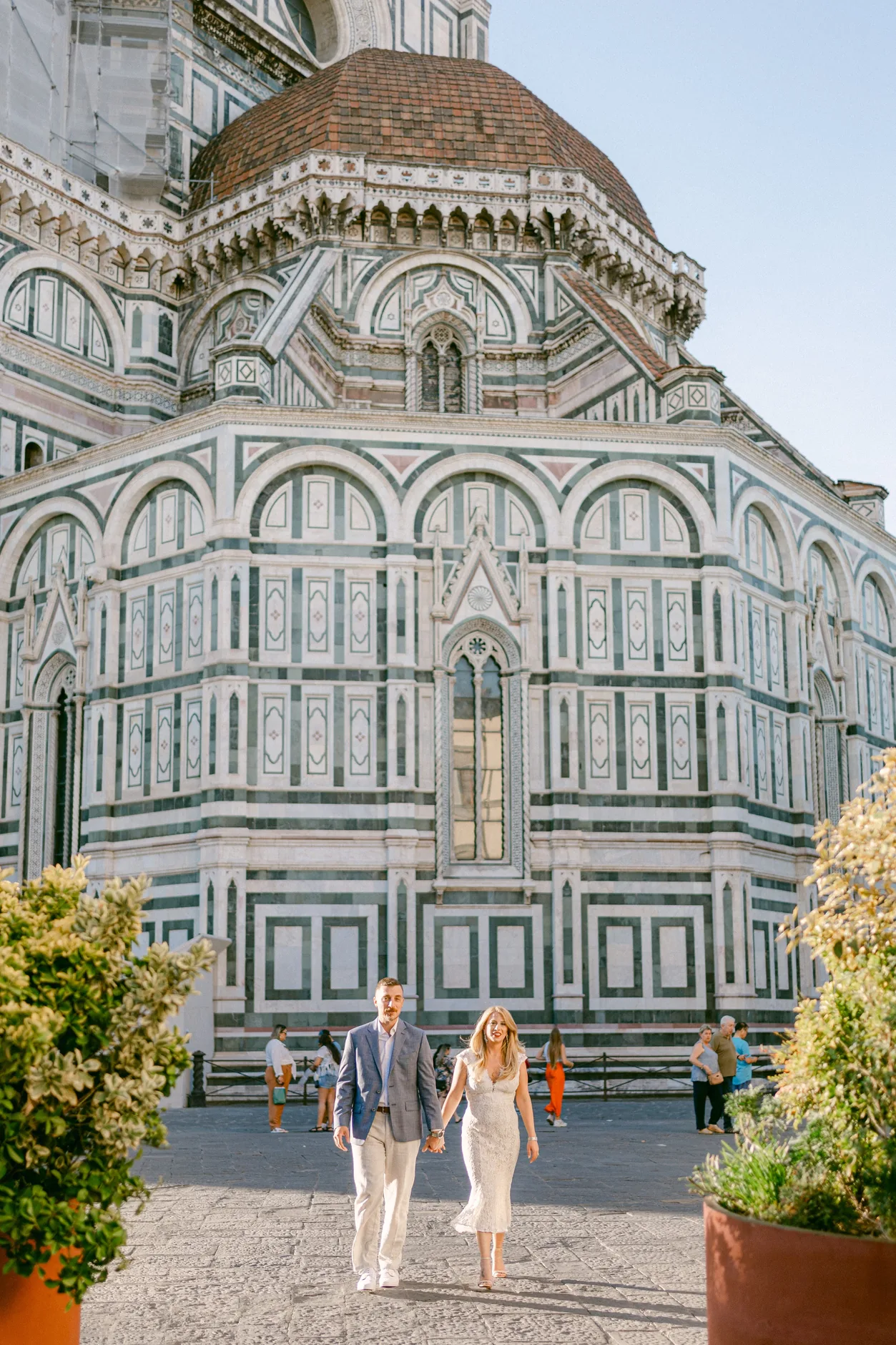 Gli sposi camminano davanti all'abside del Duomo, sotto la cupola del Brunelleschi