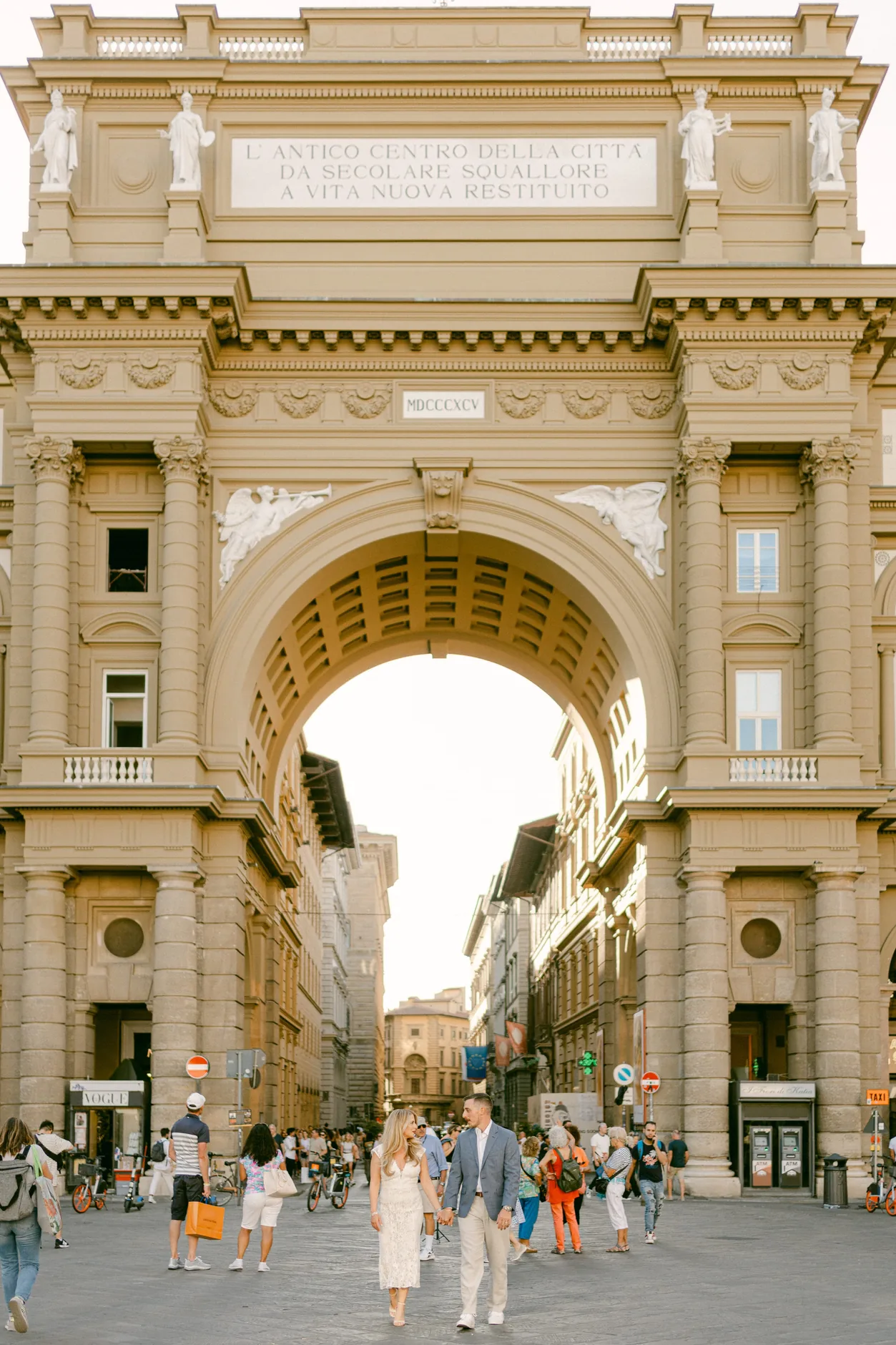 Danielle e Daniel passeggiano sotto l'arco di Piazza della Repubblica a Firenze
