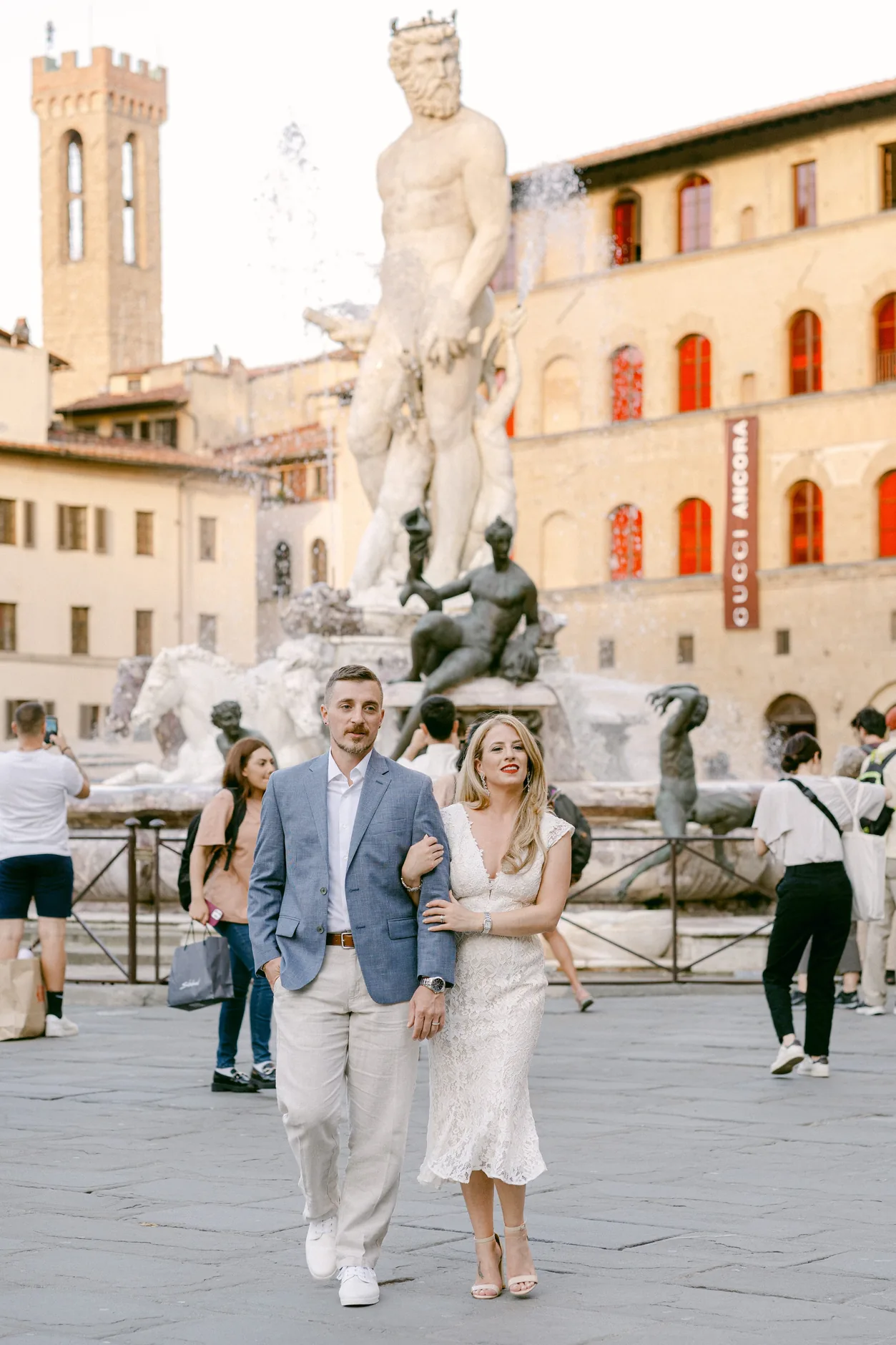 Gli sposi camminano in Piazza della Signoria, davanti alla Fontana del Nettuno
