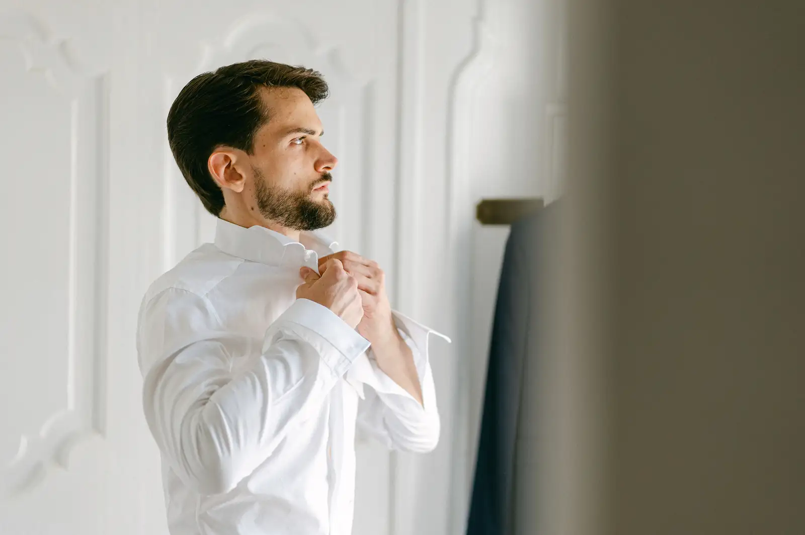 Lo sposo si prepara davanti alla finestra il giorno del matrimonio