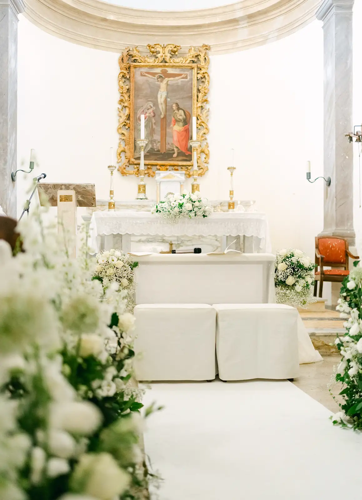 L'altare della chiesa allestito con composizioni floreali bianche