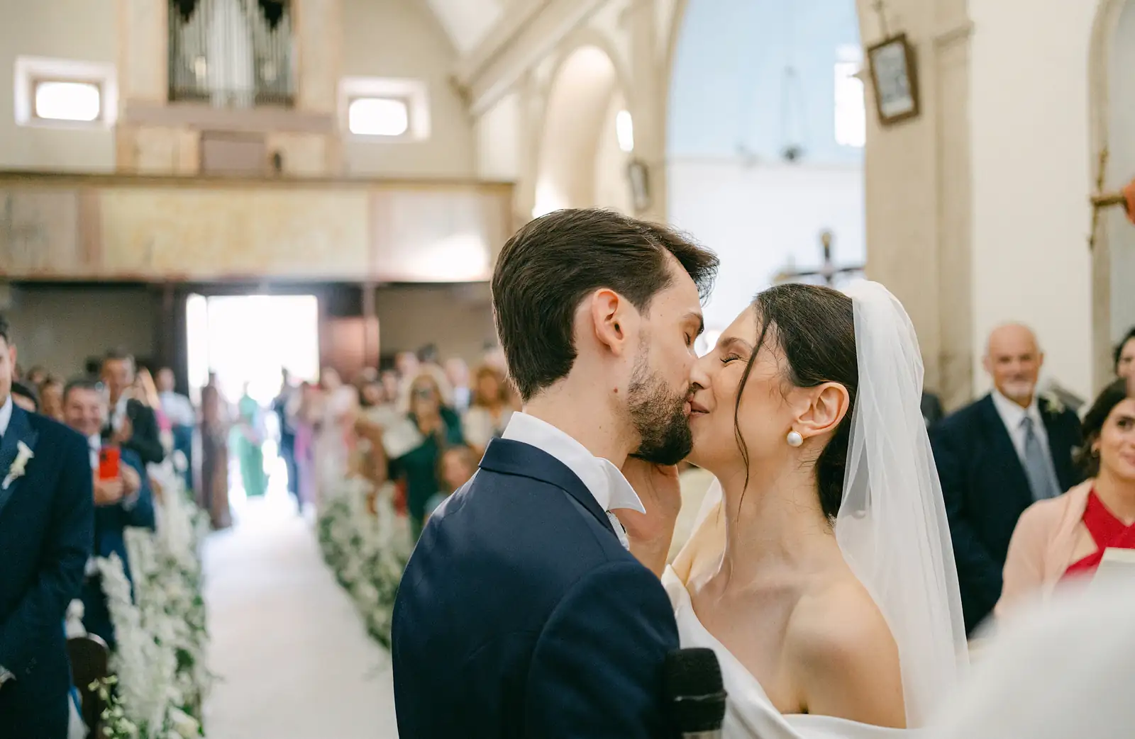 Il bacio degli sposi all'uscita dalla chiesa, tra gli invitati