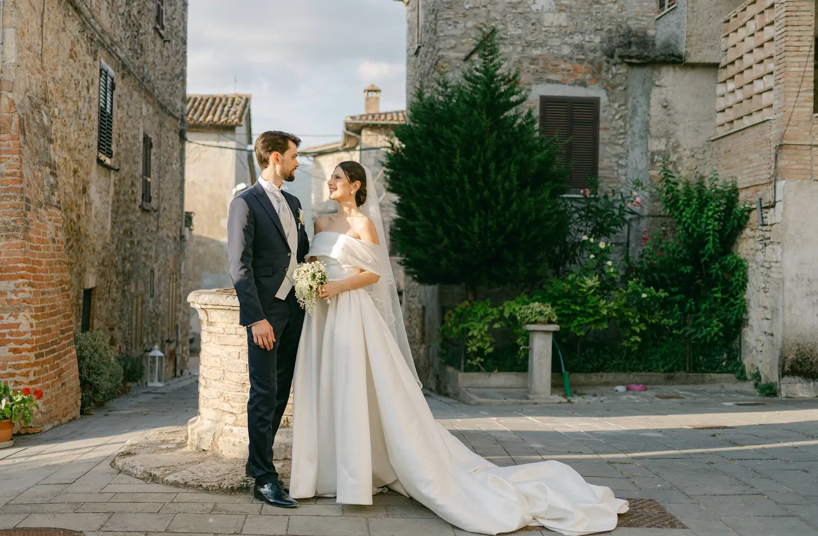 Gli sposi ritratti tra gli edifici in pietra del borgo
