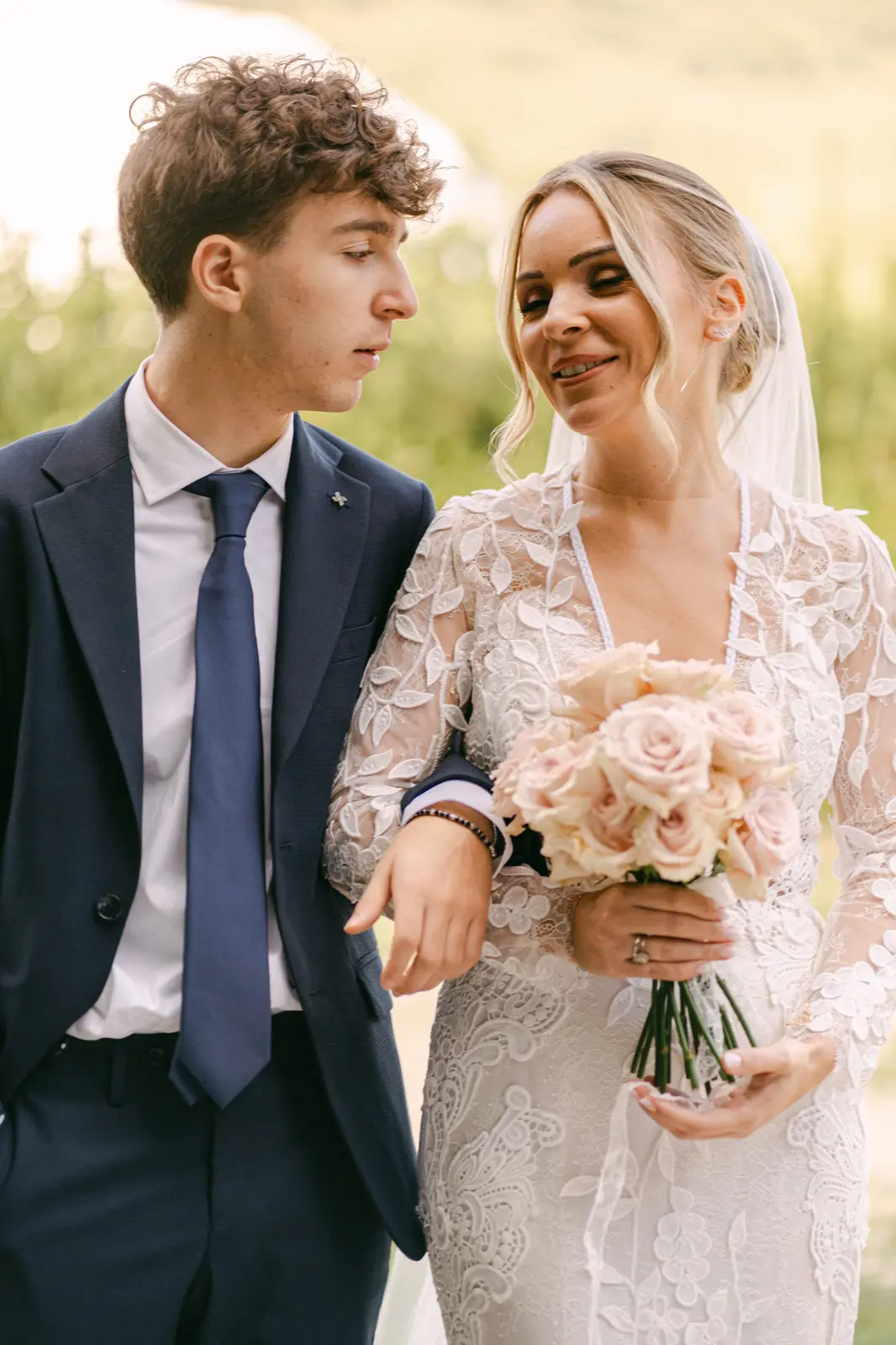 La sposa con il bouquet accompagnata da un invitato