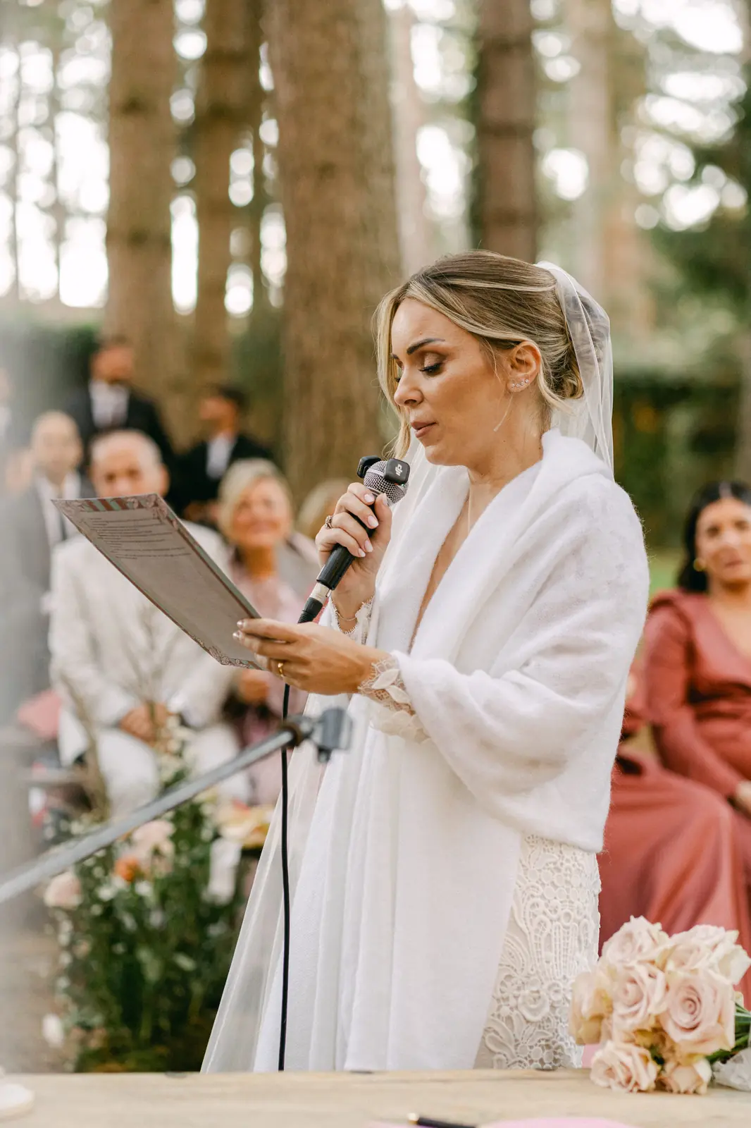 La sposa legge le promesse al microfono durante la cerimonia
