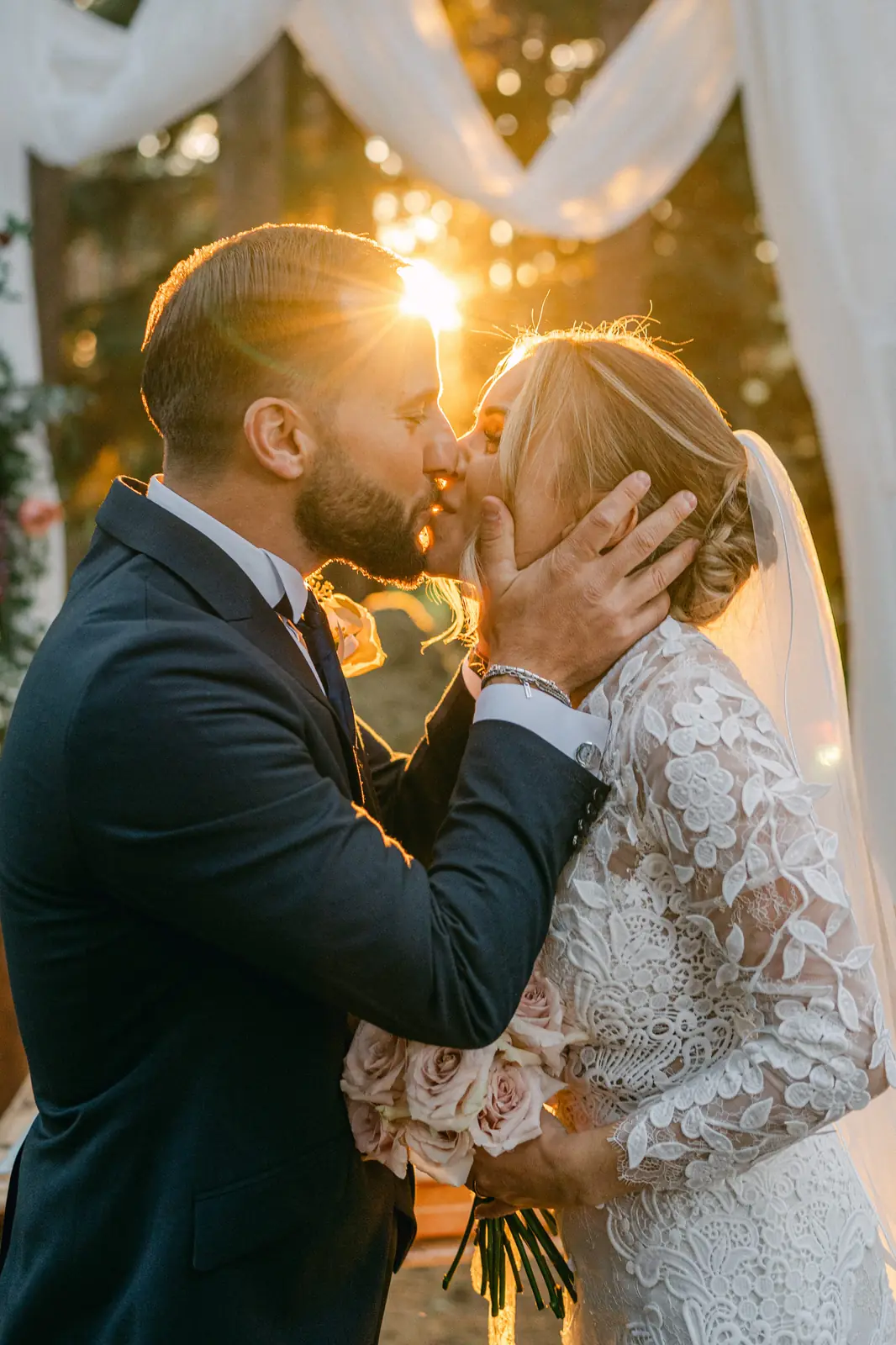 Il primo bacio degli sposi in controluce al tramonto