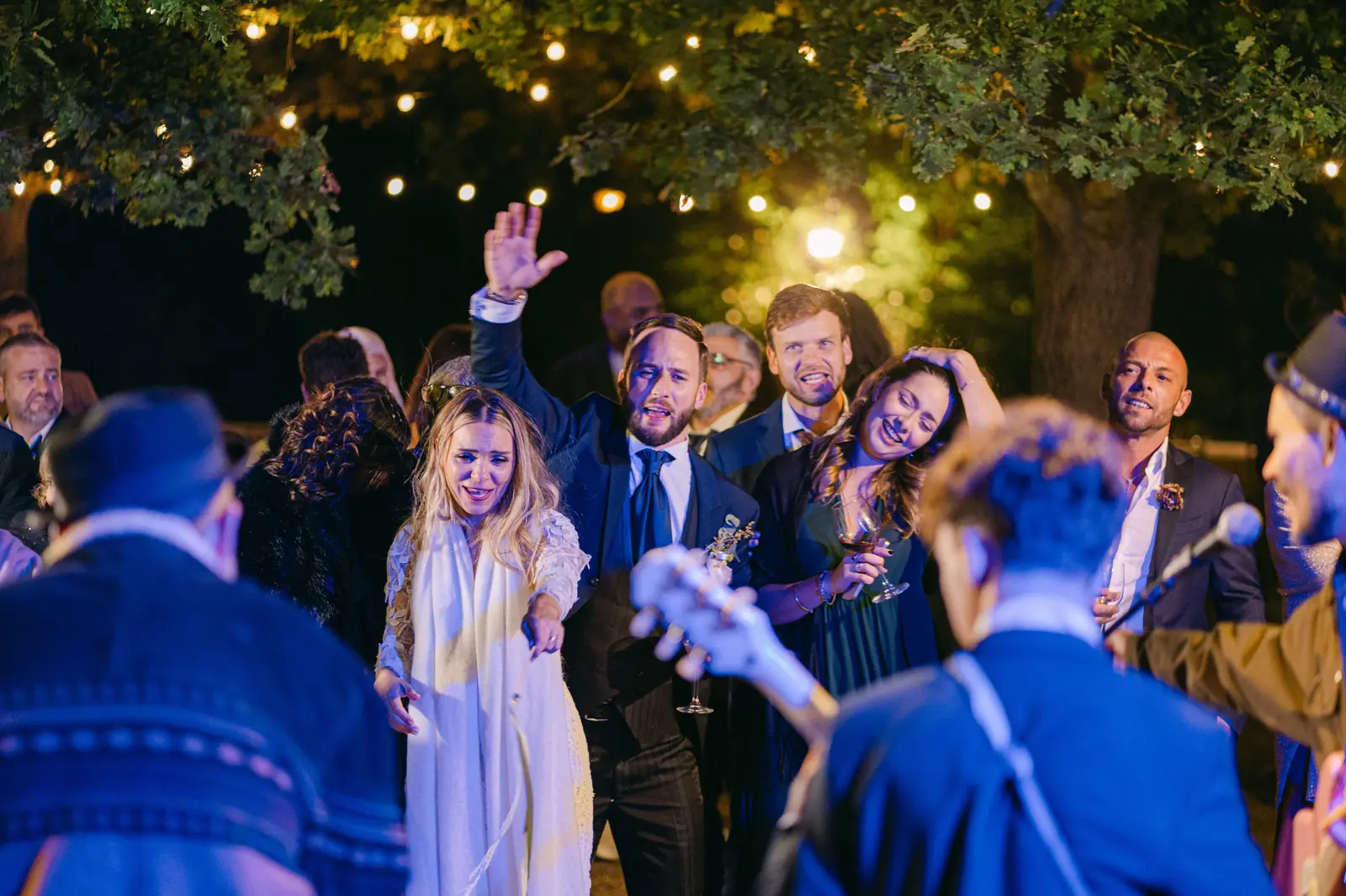 La festa serale sotto le luci con gli sposi e gli invitati