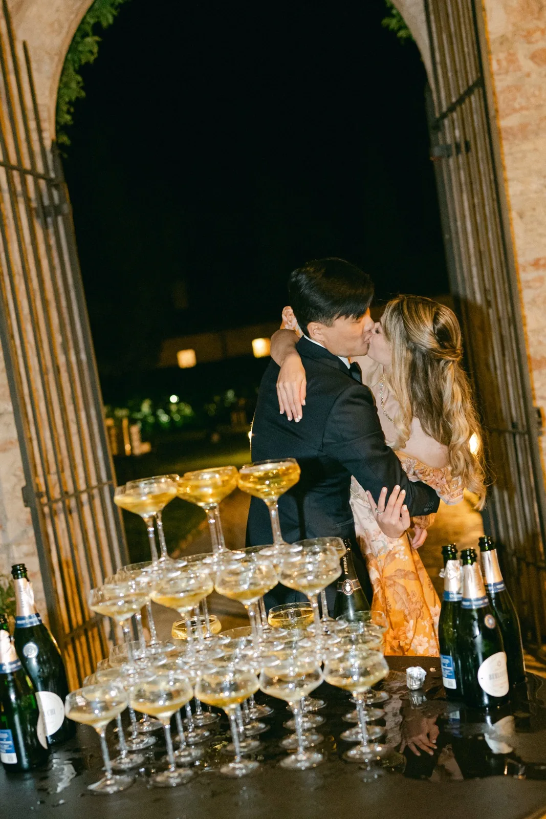 Il bacio di Julie e King dietro la torre di champagne