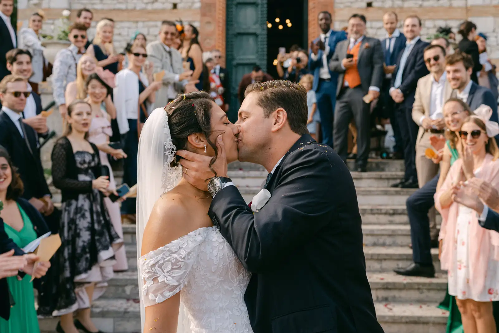 Il bacio degli sposi all'uscita dalla chiesa, tra gli invitati