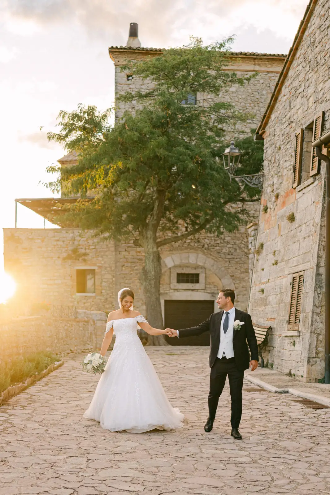 Gli sposi tra i vicoli in pietra del borgo al tramonto